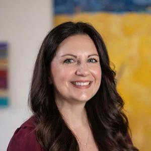 Portrait photo of Tina in professional attire.