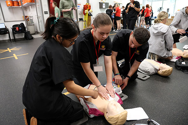 students practice CPR on a test dummy