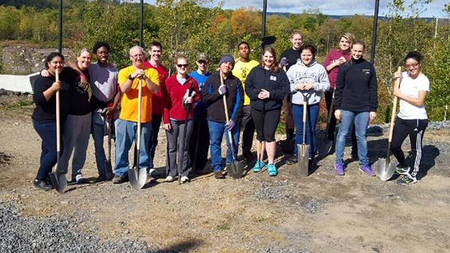 Students pose with shovels at FallSERVE