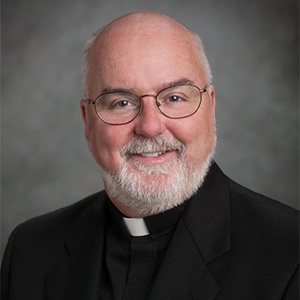 Portrait photo of Rev. O'Hara in professional attire.