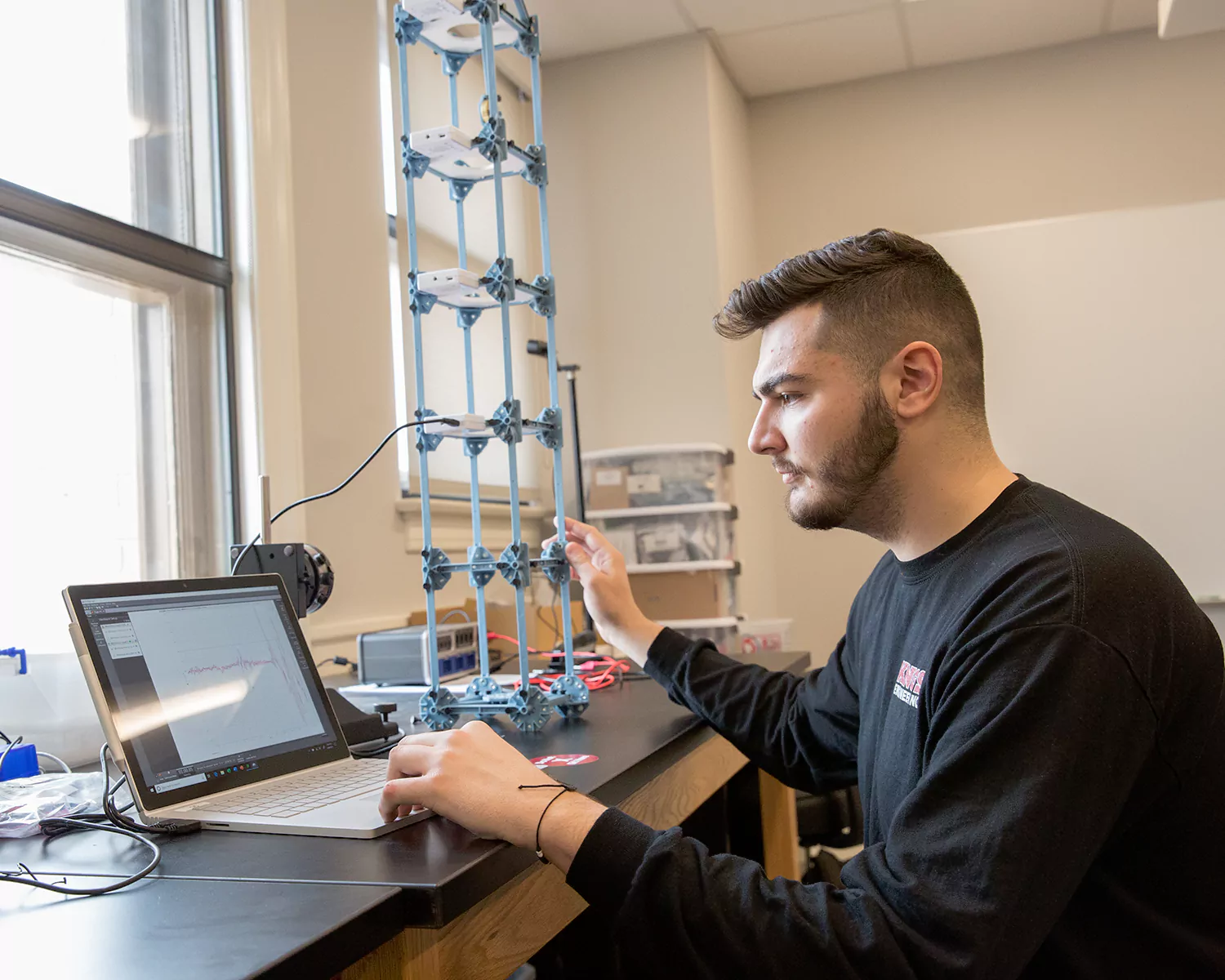 Civil engineering student interacts with a computer and K'nex