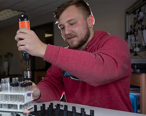 engineering student fills test tubes in an engineering lab