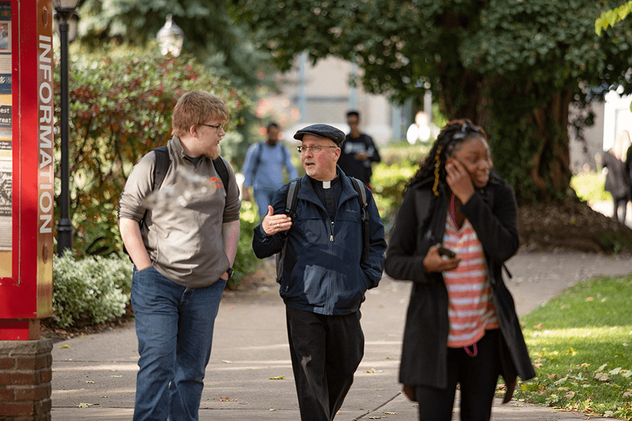 Students on the campus walkways with Father Issing.