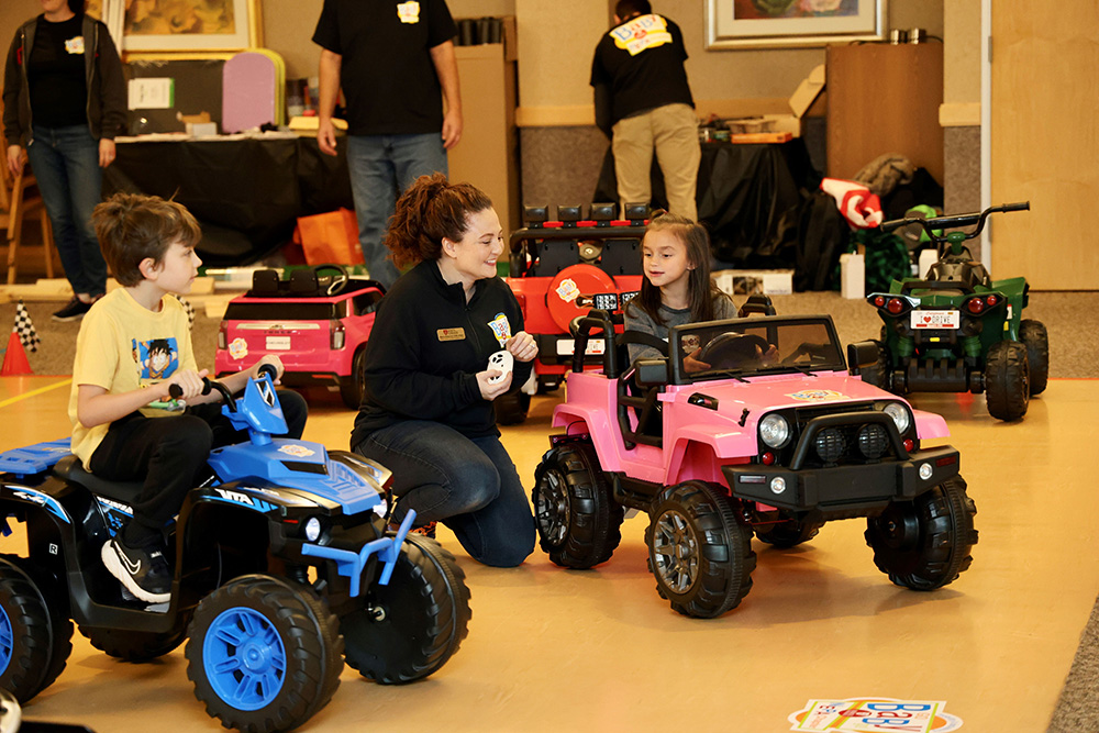 Children operating the toy vehicles assembled by the volunteers
