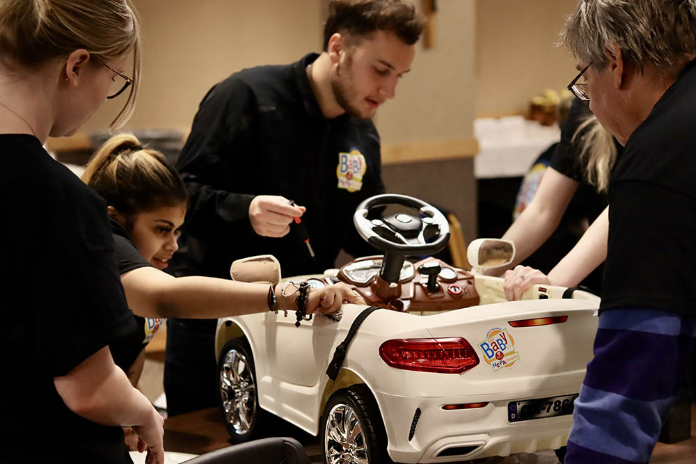 faculty and students prepare a toy vehicle for accessibility modifications