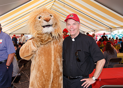 Fr. Looney poses with Leo the Lion