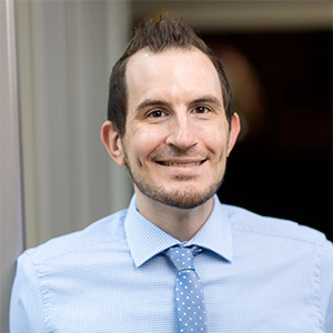 Portrait photo of Joshua Ulanoski in professional attire.