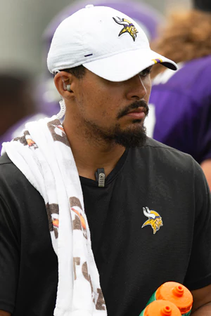 Andres holds a sports drink bottle and a towel in Minnesota Vikings apparel.