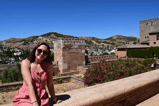 Taylor poses outside in a sprawling landscape in Spain.