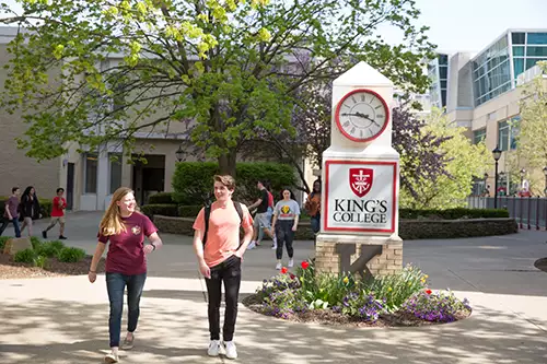 Students walking outdoors on the campus green.