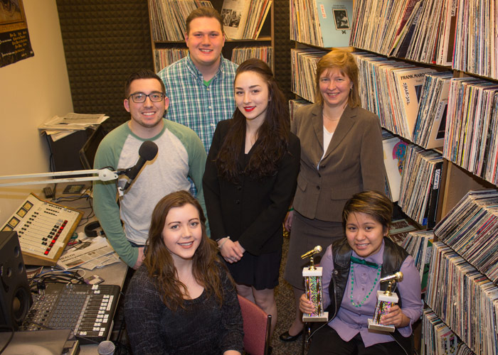 Pictured seated, from left, is Brielle Warren, news reporter, and Kristina Atienza, station manager.  Pictured in second row, from left, is Nicholas Rotondo, news director, Therese Roughsedge, music director, and Sue Henry, station manager.  Pictured in b